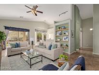 Bright living room featuring neutral furniture, a ceiling fan, and charming built-in shelving at 3055 N Red Mtn # 77, Mesa, AZ 85207
