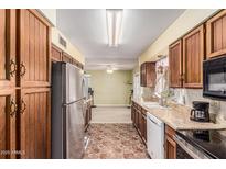 Traditional kitchen with stainless steel refrigerator and tile flooring offers a cozy atmosphere at 421 S 113Th Way, Mesa, AZ 85208