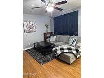 Comfortable living room with gray sofa, coffee table, and ceiling fan at 520 N Stapley Dr # 265, Mesa, AZ 85203
