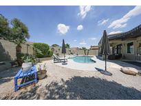 Inviting backyard pool with lounge chairs, umbrellas, and desert landscaping on a sunny day at 5416 W Village Dr, Glendale, AZ 85308
