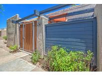Charming gated entrance with wood and blue accents surrounded by lush landscaping at 620 S Allred Dr, Tempe, AZ 85288