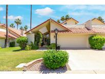 Charming home featuring a well-maintained lawn, mature landscaping, and a two-car garage at 7115 E Buena Terra Way, Paradise Valley, AZ 85253