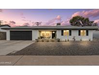 Charming single-story home with a dark-colored garage door and well-maintained landscaping in the front yard at 8341 E Hubbell St, Scottsdale, AZ 85257