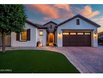 Inviting home exterior with a well-manicured lawn, beautiful stonework, and a welcoming entrance at 15803 W Almeria Rd, Goodyear, AZ 85395