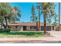 Charming ranch-style home featuring desert landscaping, mature trees, and an attached two-car garage at 1810 W Orchid Ln, Phoenix, AZ 85021