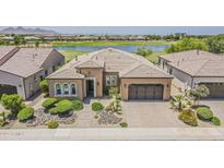 Stunning single-story home with lush landscaping, neutral tones, three-car garage, and a beautiful view of the golf course and lake at 36172 N Secret Garden Path, Queen Creek, AZ 85140