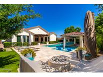 Outdoor oasis with a sparkling pool, lounge chairs, fire pit, and covered patio perfect for entertaining at 4332 S Oregon Ct, Chandler, AZ 85248