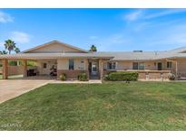 Inviting single-story home featuring well-manicured lawn and convenient carport for covered parking at 10895 W Clair Dr, Sun City, AZ 85351