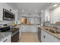 Modern kitchen with stainless steel appliances, granite countertops, and ample storage at 10895 W Clair Dr, Sun City, AZ 85351