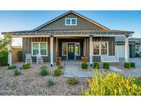 Charming front porch with swing, landscaping, and stone pathway at 11534 N Jerome St, Surprise, AZ 85388