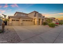Charming two-story home with three-car garage, balcony, and manicured front yard at 13824 W Gelding Dr, Surprise, AZ 85379