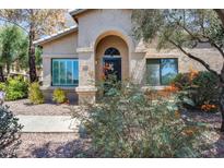 Charming home featuring a stucco facade, arched entryway, and desert landscaping at 14300 W Bell Rd # 312, Surprise, AZ 85374