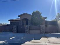 Charming single-story home featuring a private gated entrance, desert landscaping, and a welcoming covered entryway at 15625 N Jerry St, Surprise, AZ 85378