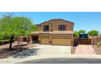 Two-story home featuring a three-car garage, landscaped front yard, and a large driveway with RV gate at 1932 S 220Th Dr, Buckeye, AZ 85326