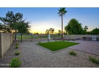A landscaped backyard with artificial turf, a built-in grill, and views of the surrounding golf course at 19906 N 76Th Ave, Glendale, AZ 85308