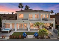 Beautiful rear exterior with a spa, lawn, outdoor seating, and lush landscaping at 2135 E Clipper Ln, Gilbert, AZ 85234