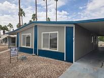 Charming manufactured home with a covered carport and desert landscaping in a well-maintained community at 3104 E Broadway Rd # 207, Mesa, AZ 85204