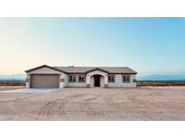 Charming single-story home featuring a neutral color scheme and attached two-car garage at 35672 W Chipman Rd, Tonopah, AZ 85354