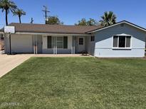 Charming home featuring a well-manicured lawn, a basketball hoop, and a welcoming porch at 4020 N 44Th Pl, Phoenix, AZ 85018