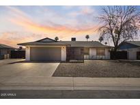 Inviting single-story home with a two-car garage, enhanced by a beautiful sunset backdrop at 4415 S Poplar St, Tempe, AZ 85282