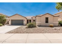Attractive single-Gathering home featuring low maintenance landscaping and a spacious driveway leading to a two-car garage at 4520 N 151St Dr, Goodyear, AZ 85395