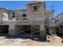 New construction of a two-story home with stucco exterior and scaffolding around the facade at 5831 E Covey Ln, Phoenix, AZ 85054