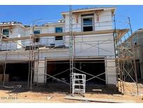 New construction home featuring a two-story design and attached garages with scaffolding at 5839 E Covey Ln, Phoenix, AZ 85054