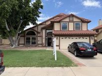 Charming two-story home featuring a lush front yard and a classic tile roof at 956 N 58Th St, Mesa, AZ 85205