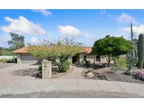 Charming single-story brick home featuring mature desert landscaping, a tile roof, and an attached two-car garage at 13019 N 23Rd Pl, Phoenix, AZ 85022