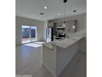 Bright kitchen featuring stainless steel appliances, gray cabinets, and a quartz countertop island at 14860 S Capistrano Rd, Arizona City, AZ 85123