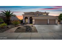 Inviting two-story home with a three-car garage, desert landscaping, and beautiful sunset skies at 16608 S 16Th Ave, Phoenix, AZ 85045