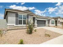 Charming single-story home with gray stucco, stone accents, a two-car garage, and low maintenance landscaping at 17773 W Onyx Ave, Waddell, AZ 85355