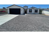 Beautifully renovated single-story home with a modern exterior, new garage door, and low-maintenance gravel yard at 1835 E Burgess Ln, Phoenix, AZ 85042