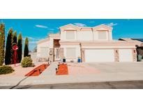 Beautiful two-story home showcasing a well-manicured lawn, lovely landscaping, and a charming red windmill at 2130 N Cypress Point N Way, Casa Grande, AZ 85122