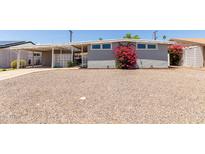 Charming home featuring a spacious gravel yard and a beautiful bougainvillea in front at 2210 E Birchwood Ave, Mesa, AZ 85204