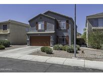 Charming two-story home featuring a gray stucco exterior and a two-car garage at 36562 W Nina St, Maricopa, AZ 85138