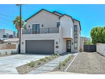Beautiful two-story home with a gray two car garage and manicured front yard at 3831 N 8Th St, Phoenix, AZ 85014