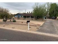 Charming single-story home with mature trees and desert landscaping on an overcast day at 6841 E Vista Dr, Paradise Valley, AZ 85253