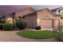 Inviting home exterior featuring a three car garage, desert landscaping, and a touch of artificial grass at 689 E Stottler Dr, Gilbert, AZ 85296
