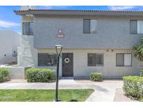 Inviting condo with desert landscaping, green grass, and mature trees at 745 N Dobson Rd # 144, Mesa, AZ 85201
