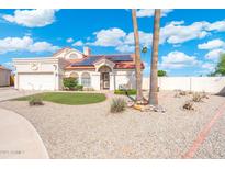 Charming single-story home with manicured desert landscaping, solar panels and a red tile roof at 7503 W Julie Dr, Glendale, AZ 85308