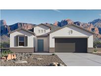 Charming single-story home boasts a stucco exterior, desert landscaping, and stunning mountain views in the background at 9357 S Mineros Dr, Apache Junction, AZ 85120