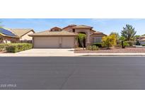 Charming single-story home featuring a spacious three-car garage and a well-maintained, landscaped front yard at 10936 N Ventana W Dr, Peoria, AZ 85373