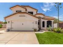 Charming two-story home with a well-manicured lawn, desert landscaping, and a two-car garage at 2934 S Woodruff Cir, Mesa, AZ 85212