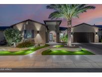 Stunning home exterior with a lush lawn, mature palm tree and welcoming walkway at twilight at 30404 N 131St Dr, Peoria, AZ 85383