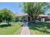 Charming home with a welcoming walkway, mature trees, and well-maintained landscaping creating great curb appeal at 325 W Loma Ln, Phoenix, AZ 85021