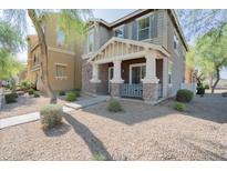 Charming two-story home featuring a covered front porch with stone accents and a well-maintained landscaped yard at 34979 N 30Th Ave, Phoenix, AZ 85086