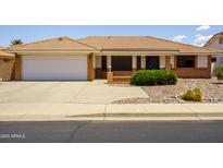 Single story home with a two car garage, desert landscaping, a terracotta roof and a well manicured lawn at 8230 E Navarro Ave, Mesa, AZ 85209