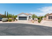 Charming home featuring desert landscaping, a gray garage door and a tile roof at 9791 N 118Th Way, Scottsdale, AZ 85259