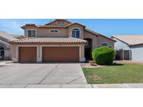 Charming two-story home featuring a well-maintained lawn, a brown-tone tile roof, and a three car garage at 1711 W Houston Ave, Gilbert, AZ 85233